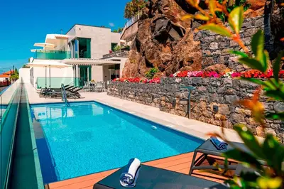 a swimming pool in front of a villa at OurMadeira - GrandView in Funchal