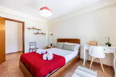 a bedroom with a bed with a red blanket at Casa May - Spacious family home with great outdoors! in Aljezur
