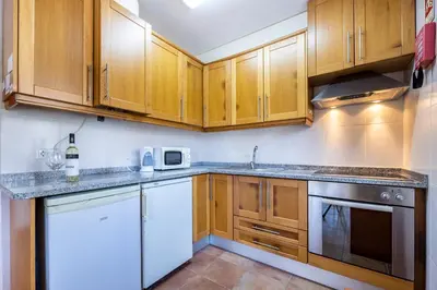 a kitchen with wooden cabinets and white appliances at Casa May - Spacious family home with great outdoors! in Aljezur