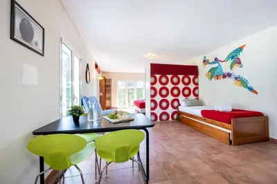 a room with a bed and a table and green chairs at Casa May - Spacious family home with great outdoors! in Aljezur