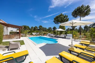 a pool with lounge chairs and an umbrella at Casa May - Spacious family home with great outdoors! in Aljezur