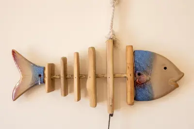 a wooden fish and sticks hanging on a wall at Casa May - Spacious family home with great outdoors! in Aljezur