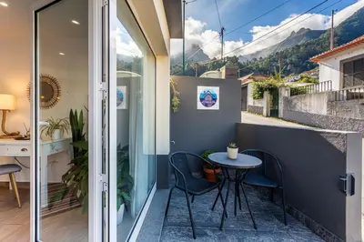a small patio with a table and chairs on a balcony at A Casa da Tia in São Vicente