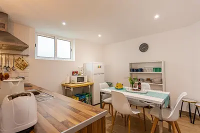 a kitchen with a table and chairs in a kitchen at A Casa da Tia in São Vicente