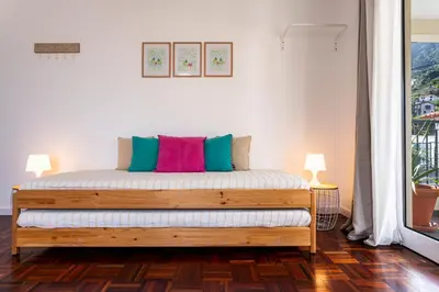 a bed in a room with two lamps at A Casa da Tia in São Vicente