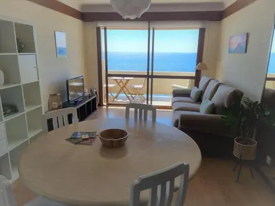 a living room with a table and a couch at come hear the ocean! in Funchal