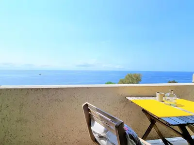 a yellow table and chairs on a balcony overlooking the ocean at come hear the ocean! in Funchal