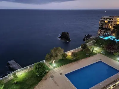 an aerial view of a swimming pool and the ocean at come hear the ocean! in Funchal
