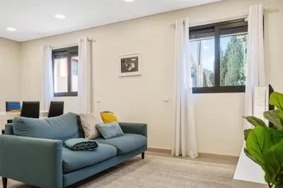 a blue couch in a living room with a window at Coração da Madeira by Homie in Curral das Freiras