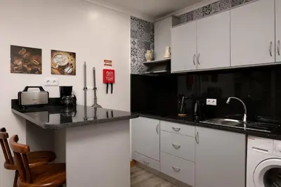 a kitchen with white cabinets and a sink at Vila do Largo by Homie in São Vicente