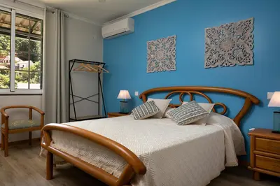 a bedroom with a bed with a blue wall at Vila do Largo by Homie in São Vicente