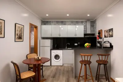 a kitchen with white cabinets and a table and chairs at Vila do Largo by Homie in São Vicente