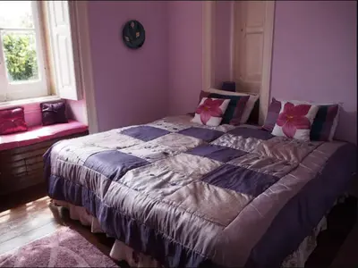 a bedroom with a large bed with pink walls at Casa Grande Portugal in Burgau