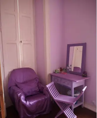 a purple room with a chair and a table with a mirror at Casa Grande Portugal in Burgau