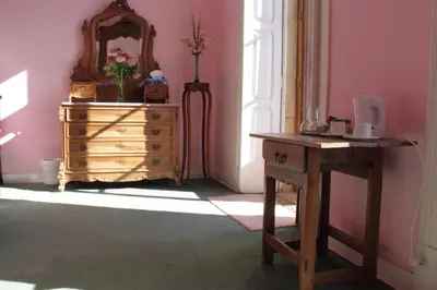 a dresser in a room with a mirror and a table at Casa Grande Portugal in Burgau