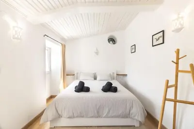 a bedroom with a white bed with two pillows on it at Casa do Al-gharb in Raposeira