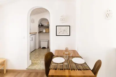 a yellow and white building with a door at Casa do Al-gharb in Raposeira