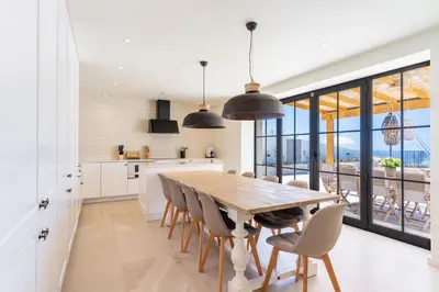a kitchen and dining room with a wooden table and chairs at Villa Horizonte Azul by Holiday Rental Madeira in Ponta do Sol