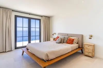 a bedroom with a bed and a large window at Villa Horizonte Azul by Holiday Rental Madeira in Ponta do Sol