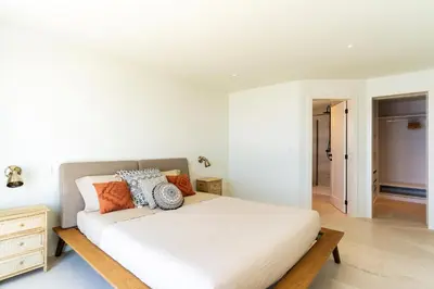a bedroom with a white bed with orange and blue pillows at Villa Horizonte Azul by Holiday Rental Madeira in Ponta do Sol