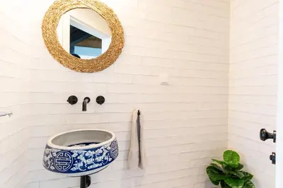 a bathroom with a blue and white sink and a mirror at Villa Horizonte Azul by Holiday Rental Madeira in Ponta do Sol