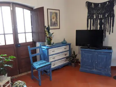 a living room with a tv and a blue chair at Agua de Sonho 2 in Bensafrim