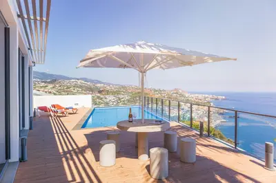 a patio with a table and an umbrella at Villa Amplitude in Câmara de Lobos