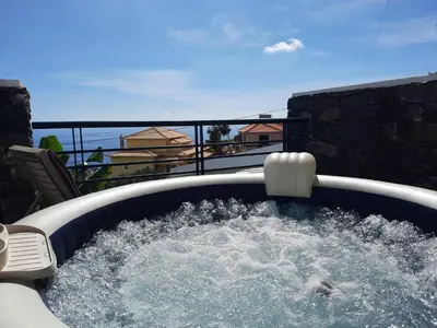 a hot tub on a balcony with water at Dr. Cabral Barreto in Ponta do Sol