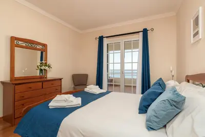 a bedroom with a large bed and a mirror at SUNNYSIDE VILLA in Calheta