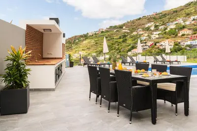 a patio with a table and chairs and a pool at SUNNYSIDE VILLA in Calheta