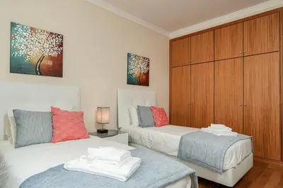 a bedroom with two beds and a wooden cabinet at SUNNYSIDE VILLA in Calheta