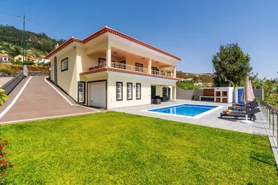 a villa with a pool and a yard at SUNNYSIDE VILLA in Calheta