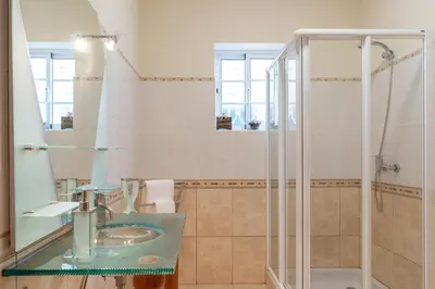 a bathroom with a glass sink and a shower at SUNNYSIDE VILLA in Calheta
