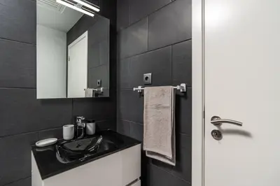 a black bathroom with a sink and a mirror at Casa Da Portada in Calheta