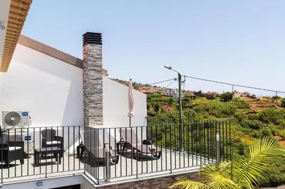 a balcony of a house with chairs on it at Casa Da Portada in Calheta