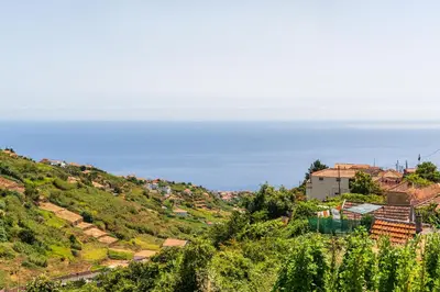 a village on a hill with the ocean in the background at Casa Da Portada in Calheta