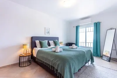 a bedroom with a bed and a large window at Casa Onda - Fabulous Ocean View Villa in Aljezur