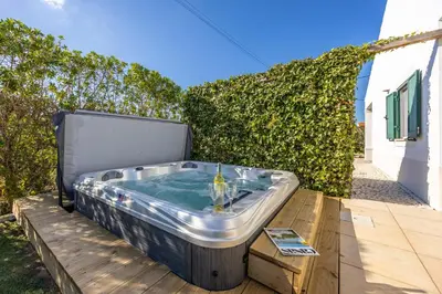 a hot tub sitting on top of a wooden deck at Casa Onda - Fabulous Ocean View Villa in Aljezur