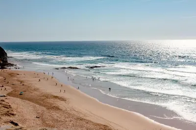 a group of people on a beach near the ocean at Casa Onda - Fabulous Ocean View Villa in Aljezur