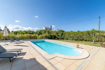 a swimming pool in a backyard with chairs and a pool at Casa Onda - Fabulous Ocean View Villa in Aljezur
