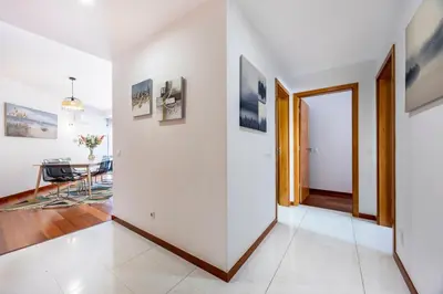 a white hallway with a dining room and a table at Sun and Sea - Baia da Luz Apartment in Luz