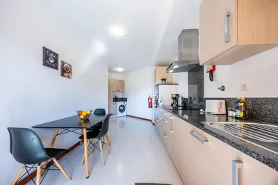a kitchen with a table and chairs in a room at Sun and Sea - Baia da Luz Apartment in Luz