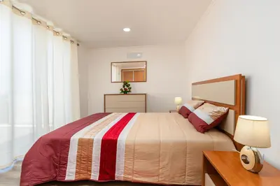 a bedroom with a bed and a table and a mirror at Casa Terra-Boa in Arco da Calheta