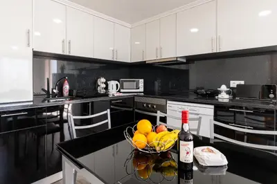 a kitchen with a bowl of fruit and a bottle of wine at Casa Terra-Boa in Arco da Calheta