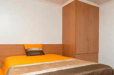 a bedroom with a bed and a wooden cabinet at Casa Terra-Boa in Arco da Calheta