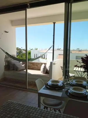 a dining room with a view of a living room at Beachfront Apartments Porto de Mós Beach - Lagos in Lagos