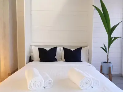 a bedroom with a white bed with two pillows at Beachfront Apartments Porto de Mós Beach - Lagos in Lagos