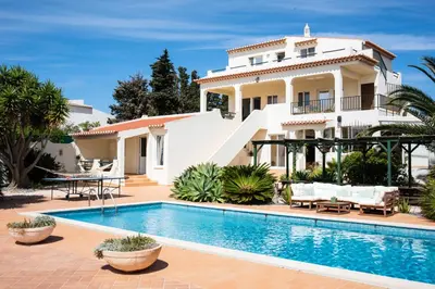 a villa with a swimming pool in front of a house at AltaVista Lodge in Luz