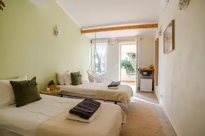 a room with two beds and a room with a window at AltaVista Lodge in Luz
