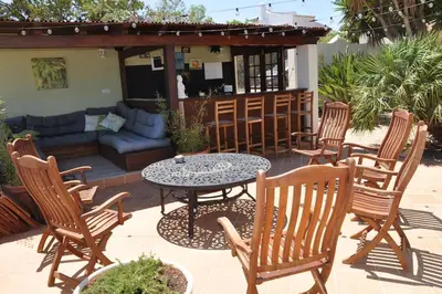 a patio with a table and chairs and a couch at AltaVista Lodge in Luz